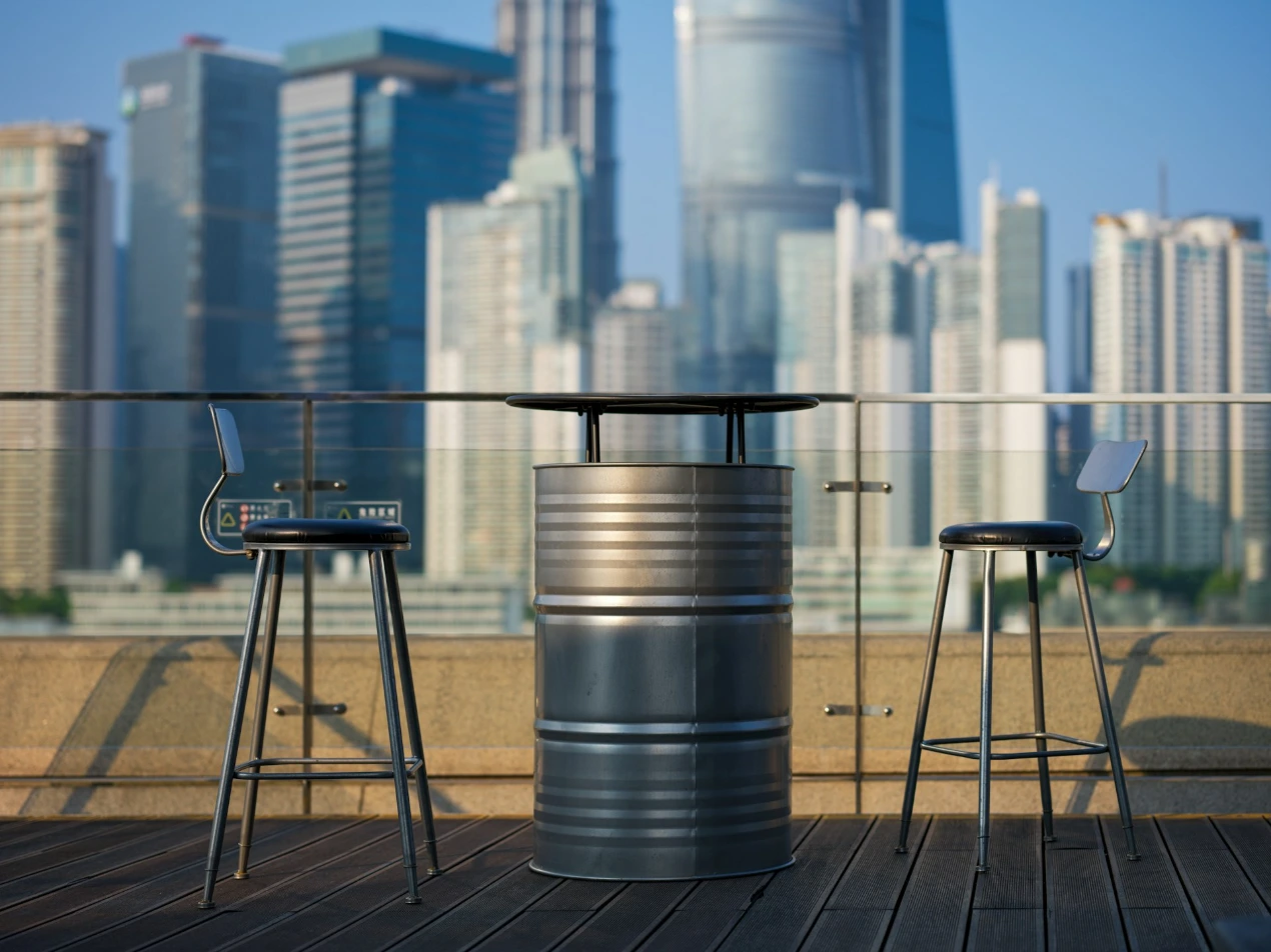Two stools and a table on a balcony with a view of a city